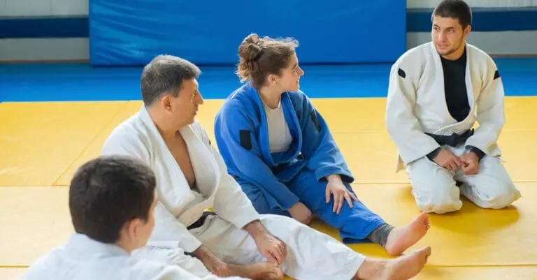 Adult students listening on mats during martial arts for adults